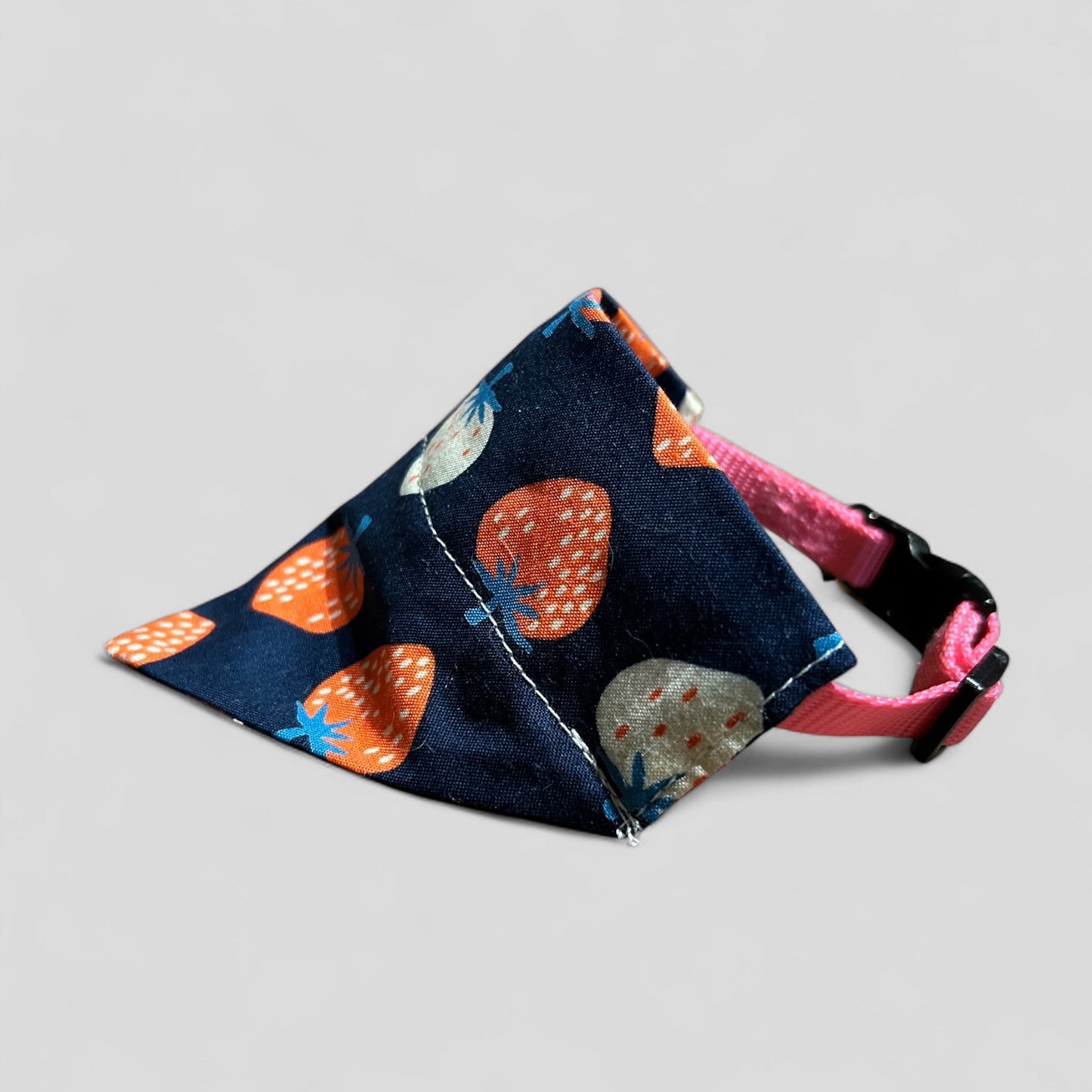 Dog muzzle with floral pattern on a pink collar against a gray background