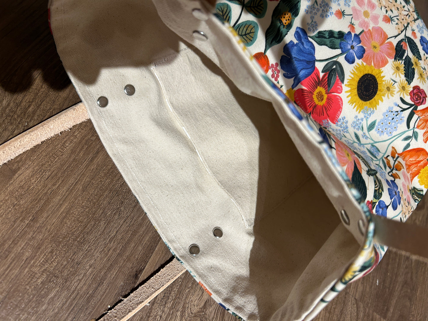 Floral-patterned fabric on a beige background with wooden floor.