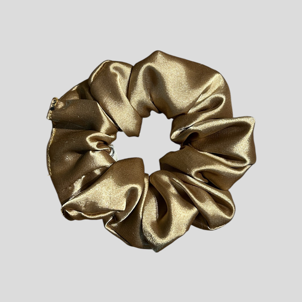 Gold scrunchie on a light gray background
