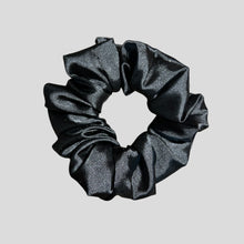 Load image into Gallery viewer, Black glittery scrunchie on a light gray background
