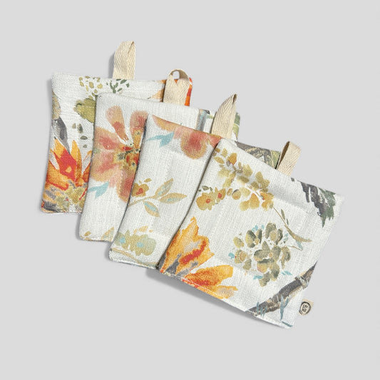Set of four floral-patterned pot holders on a light gray background