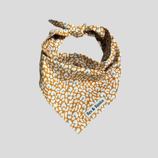 Dog bandana with orange and white pattern on a light gray background
