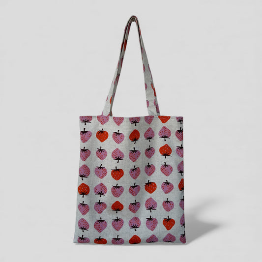 Tote bag with strawberry pattern on a light gray background