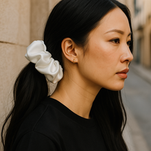 Load image into Gallery viewer, Woman with a white scrunchie in her hair against a neutral background