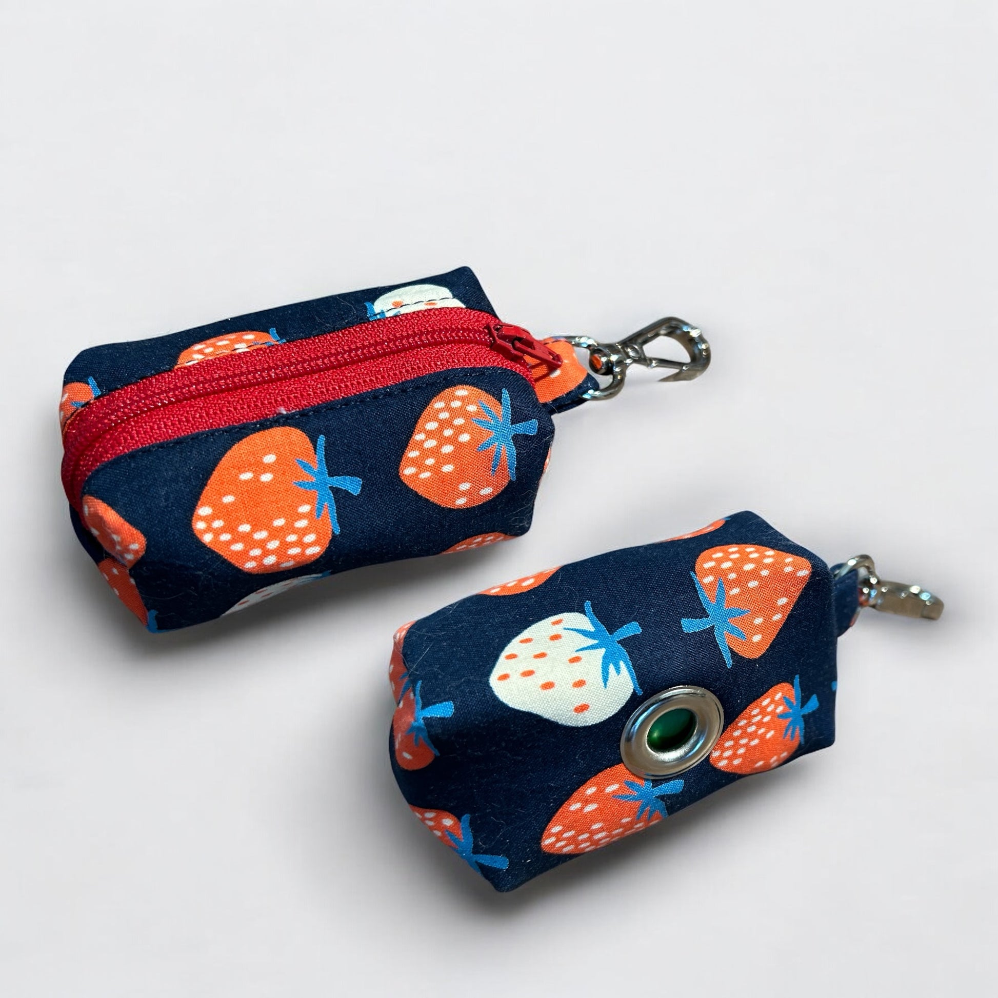 Two small pouches with strawberry pattern on a white background
