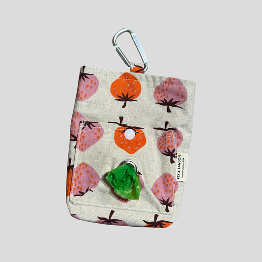 Fabric pouch with fruit pattern and carabiner clip on a light gray background