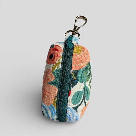 Floral patterned keychain pouch with zipper on a light gray background