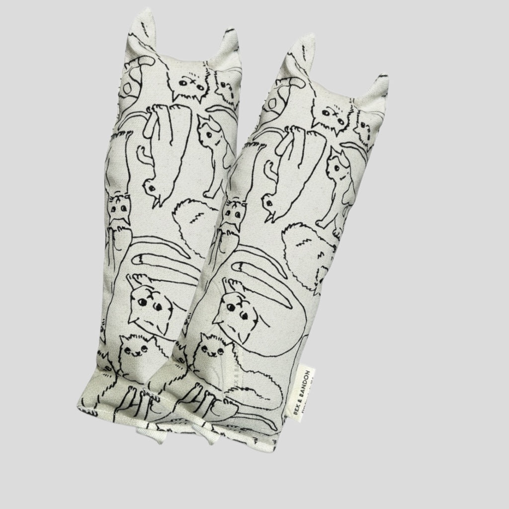 Two fabric straps with cat pattern on a light gray background