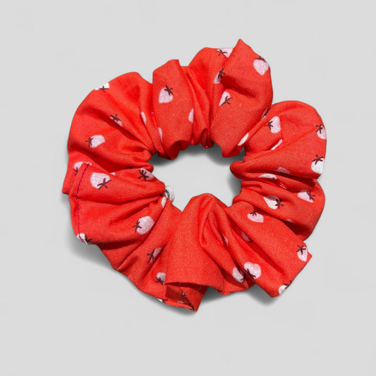 Red scrunchie with heart patterns on a gray background
