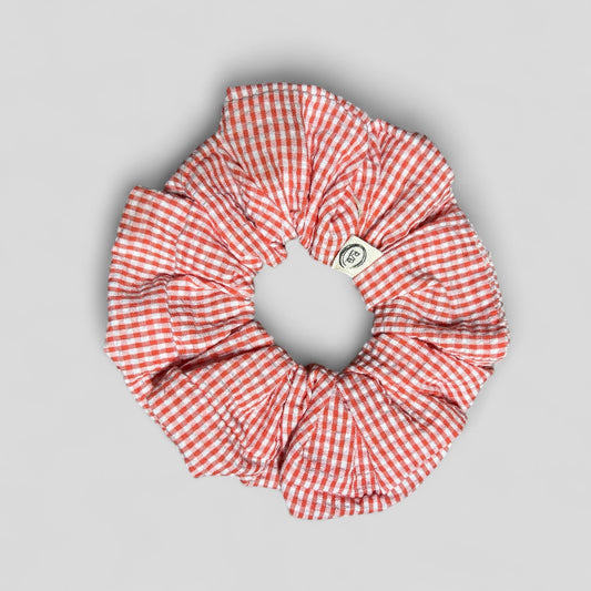 Red and white checkered scrunchie on a gray background