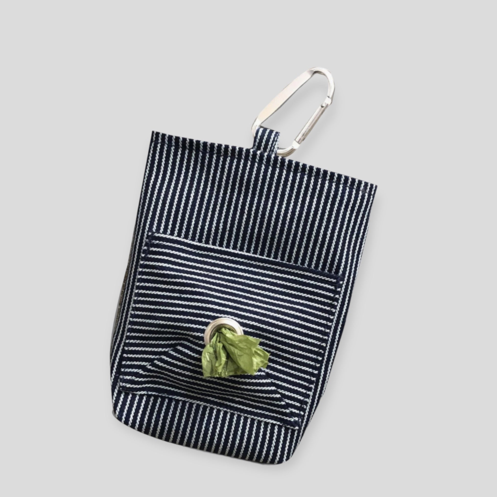 A striped cotton dog walker pouch with a front pocket and a carabiner clip, against a white background.